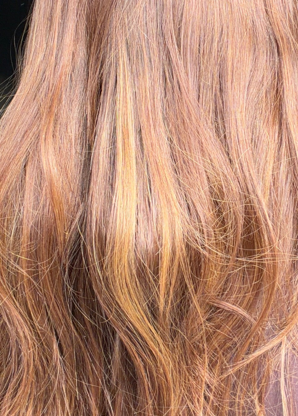 Close-up of wavy brown/red hair with highlights